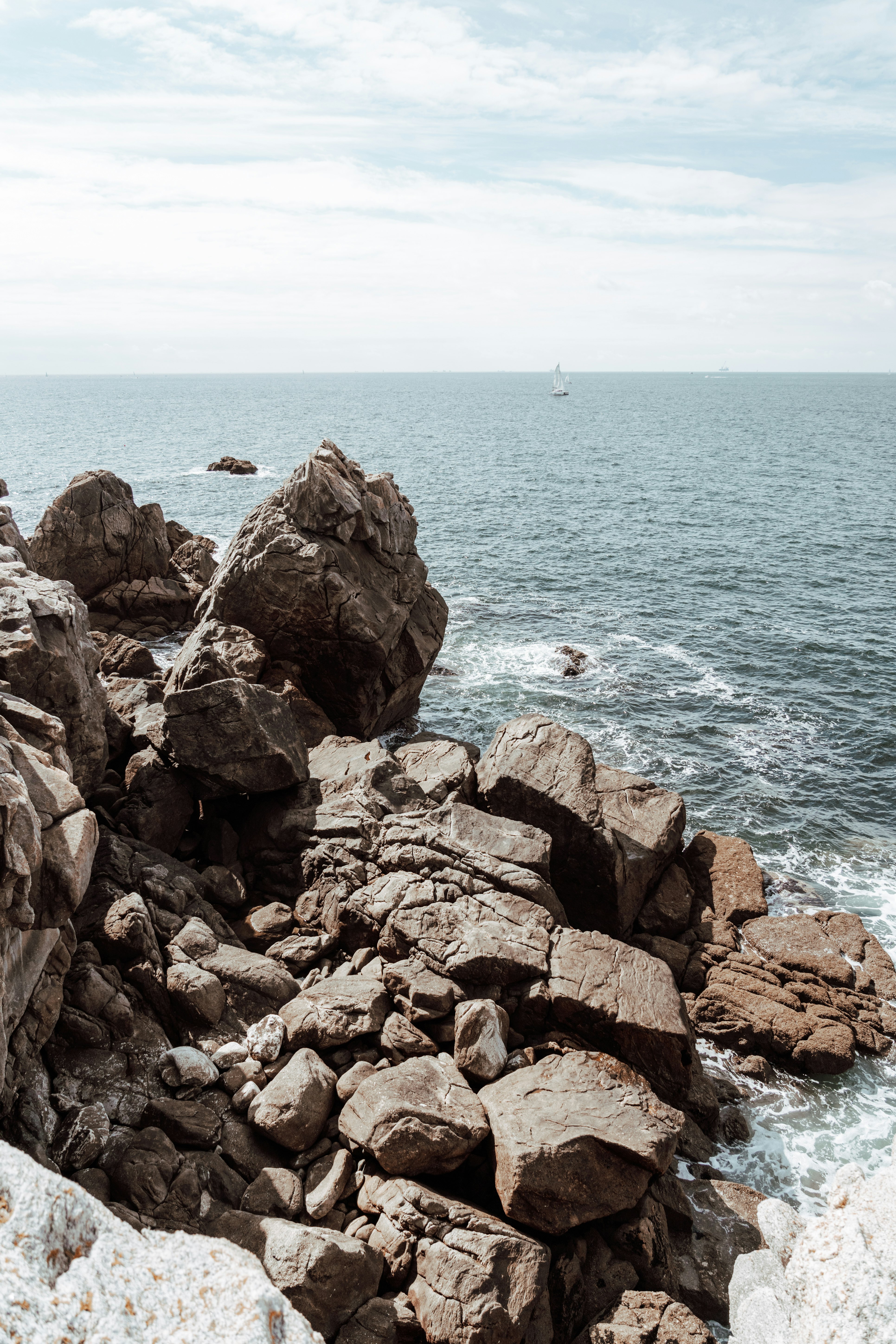 brown rocky shore with body of water during daytime